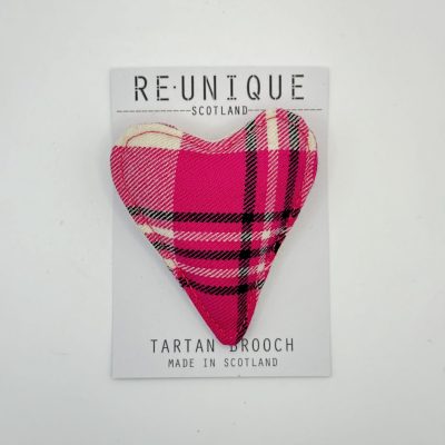 A stunning flower-shaped brooch in a delicate light purple tartan pattern is beautifully attached to a card labeled REUNIQUE SCOTLAND, featuring the words Tartan Brooch Made in Scotland. Perfect for those searching for unique Scottish accessories, this eye-catching brooch combines traditional tartan design with contemporary flair.