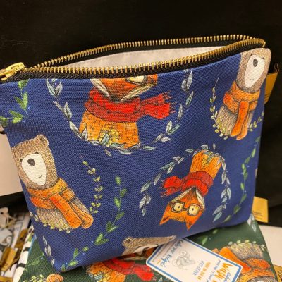 A stylish wash bag featuring woodland animals, including chic owls in scarves and glasses perched on leafy branches against a dark backdrop. Perfect for nature lovers seeking a unique accessory!.