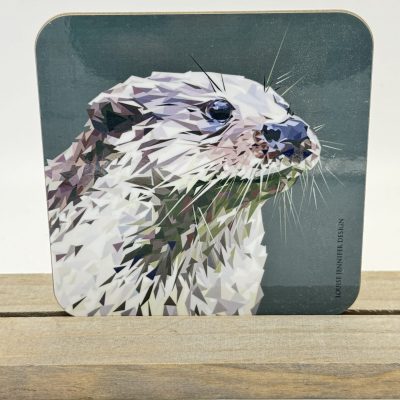 Elevate your home decor with a stunning geometric otter head coaster, beautifully set against a dark green backdrop. This unique art piece not only enhances your drinkware collection but also stands out elegantly on its custom wooden stand, making it an eye-catching display for any room. Perfect for nature lovers and geometric art enthusiasts alike, this otter coaster brings artistic flair and functionality to your space.