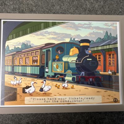 Illustration of a vintage train at a station featuring ducks and ducklings on the platform. The charming scene showcases a duck in the trains cab, adding a whimsical touch. Framed with the caption: Please have your tickets ready for the conductor, this delightful image highlights historic trains and their timeless appeal alongside adorable wildlife companions.