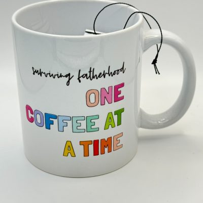 Discover the perfect gift for dads with our Surviving Fatherhood One Coffee at a Time white mug, featuring vibrant lettering. This unique coffee mug is ideal for fathers who thrive on caffeine. Complete with a tea bag string casually hanging over the rim, it captures the essence of daily dad life. The plain white background ensures all attention is on this fun and functional dad coffee cup.