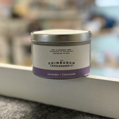 Discover the The Edinburgh Candlemaker Co. candle tin featuring a calming blend of Lavender and Chamomile. This elegant scented candle, set against a subtly blurred background, showcases its minimalist design on a light-colored surface. Perfect for creating a soothing ambiance in your home decor.
