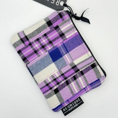 Discover our trendy pouch showcasing a vibrant plaid pattern in purple, black, white, and blue hues. This stylish accessory features a durable black zipper for secure closure and proudly displays a tag reading Re-Unique Scotland. Perfect for keeping your essentials organized while adding a touch of Scottish flair to your collection.