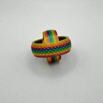 Explore our rainbow-colored fidget toy featuring interlocking rings with textured surfaces, perfect for stress relief and tactile stimulation. The outer ring boasts small bumps for added sensory feedback, while the inner ring provides a smooth texture. This visually engaging and soothing fidget toy is displayed against a plain white background, ideal for enhancing focus and relaxation.